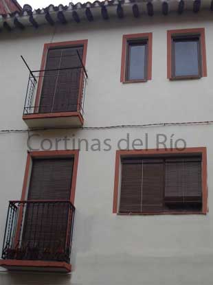 Alicantinas de madera nogal en balcones y ventanas de una casa