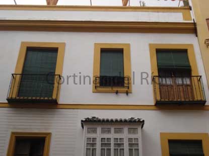 Alicantinas de madera verdes en varios balcones de fachada