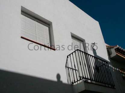 Alicantinas de plástico blancas en una ventana y en la salida al balcón