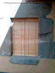 Alicantina de madera cerezo en una ventana con marco de piedra