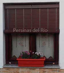Alicantina de madera nogal sobre una ventana con maceta