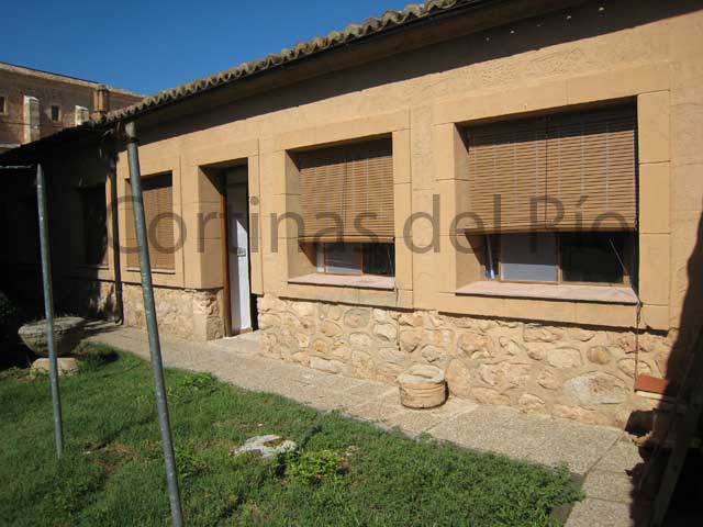 Alicantinas de plástico marrón claro en varias ventanas de una casa de piedra