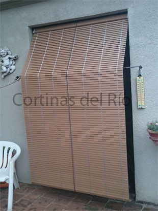 Alicantina de PVC imitación madera delante de la puerta de un porche