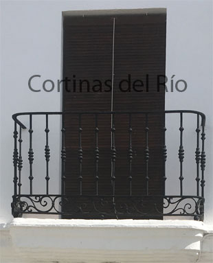 Alicantina de madera marrón oscuro delante de un balcón
