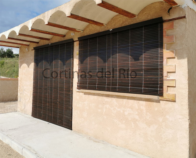 Alicantinas de madera nogal en puerta y ventana bajo un alero