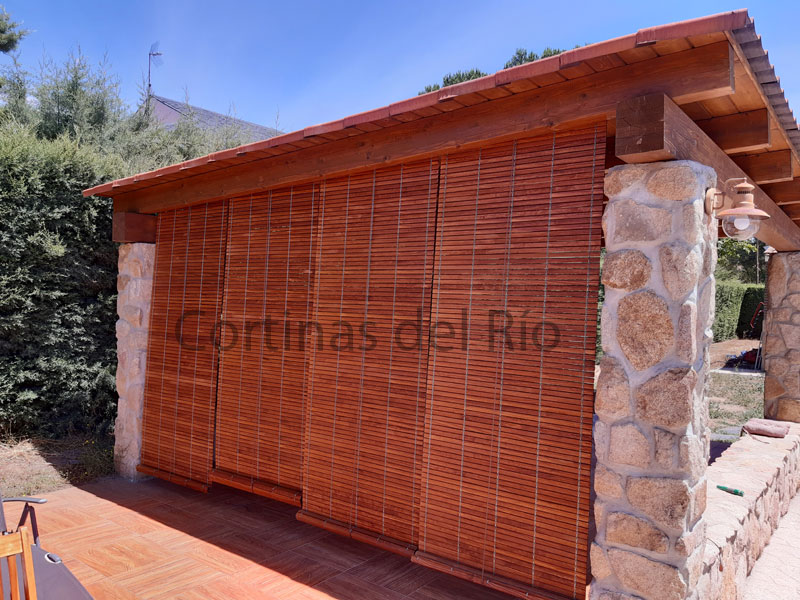 Persianas alicantinas de madera cerezo bajadas en un porche de piedra
