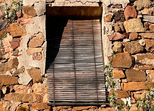 Alicantina de madera envejecida en una ventana de piedra