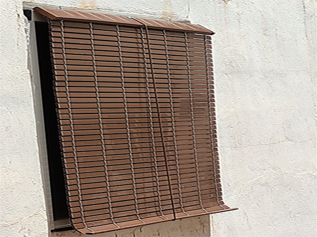 Alicantina de PVC imitación madera bajada delante de una ventana