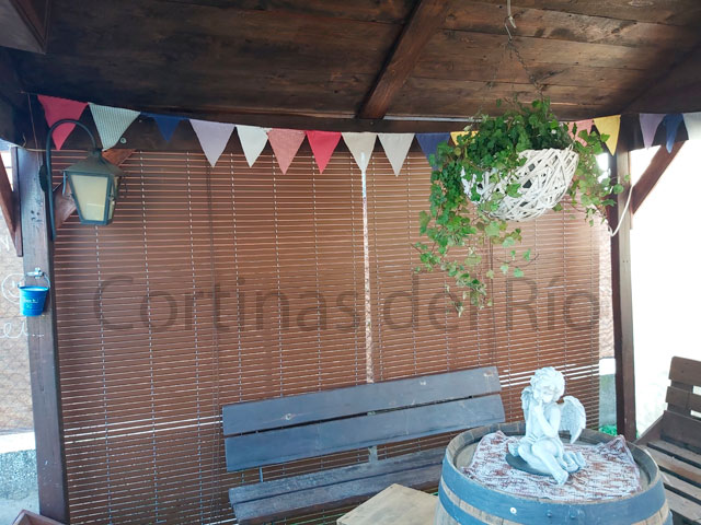 Dos alicantinas de PVC imitación madera junto al banco de un porche