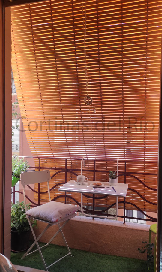 Vista interior de una alicantina de plástico imitación madera apoyada sobre la barandilla