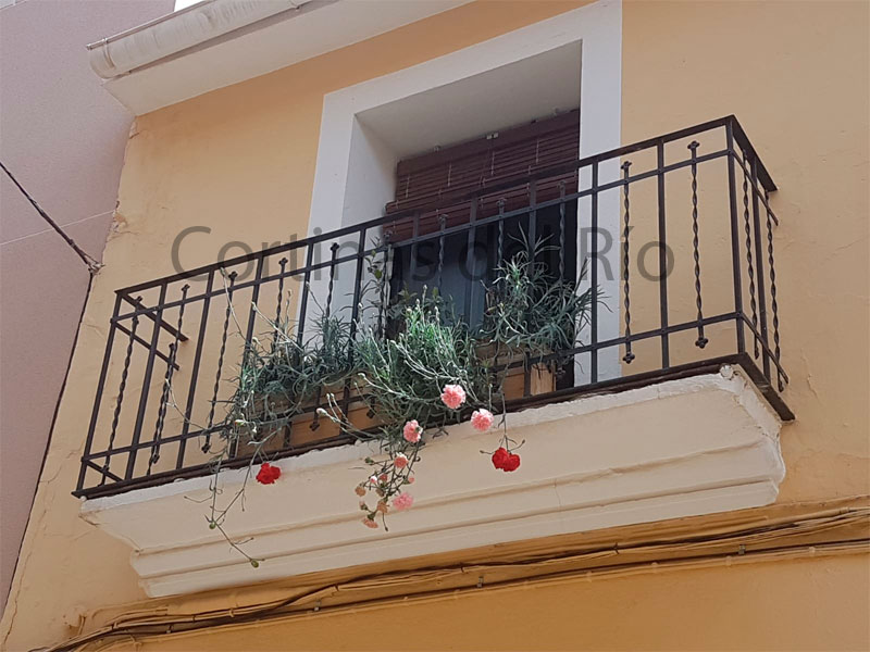 Alicantina de madera nogal en un balcón con flores