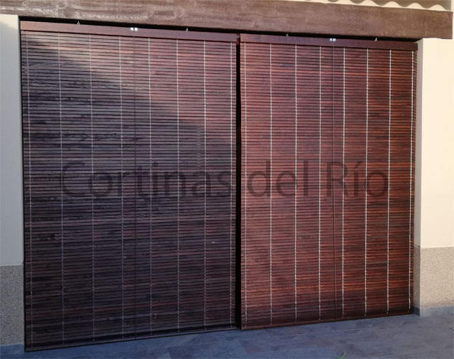Dos alicantinas de madera nogal cubren una ventana ancha de fachada