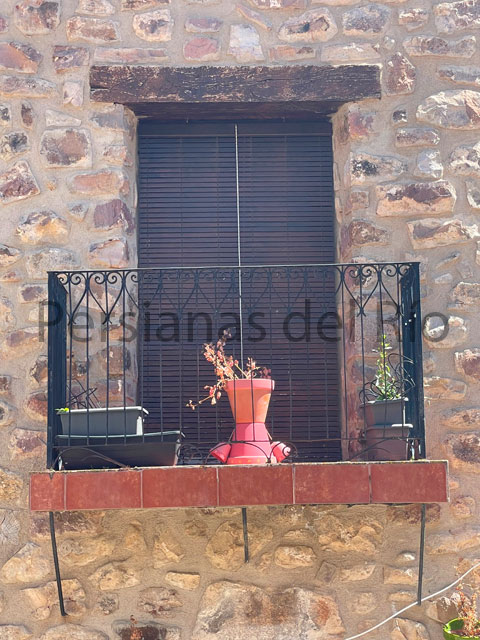 Alicantina de madera nogal en un balcón de piedra